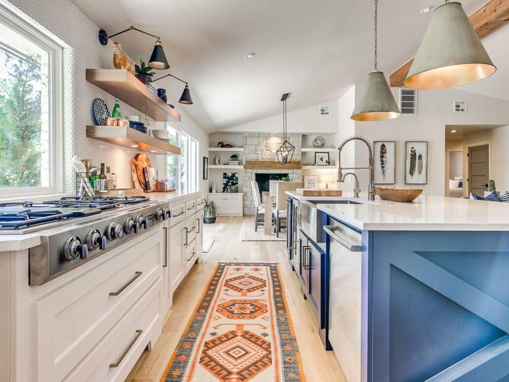 Interior of a modern open concept kitchen and dining room with white and blue cabinets